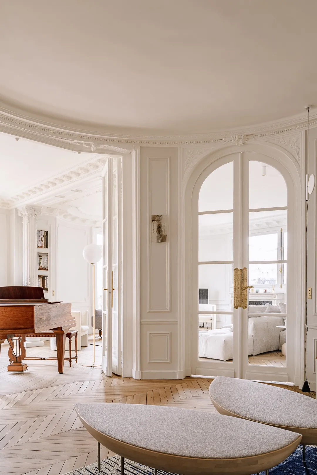 Enfilade de pièces baignées de lumière vers le piano
